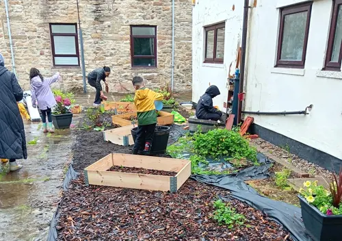 The Olive Branch young people, carers and staff planting in the garden