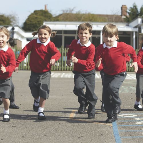 a group of primary school children looking happy in the playground