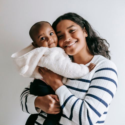 A woman looking happy holding a young baby