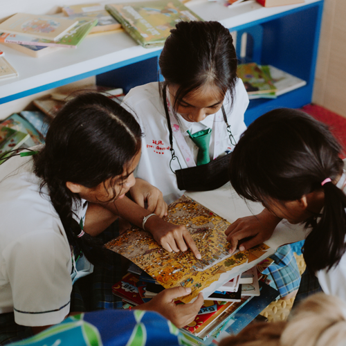 three school children working together in a classroom